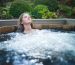 Girl relaxing in a cedar wooden hot tub